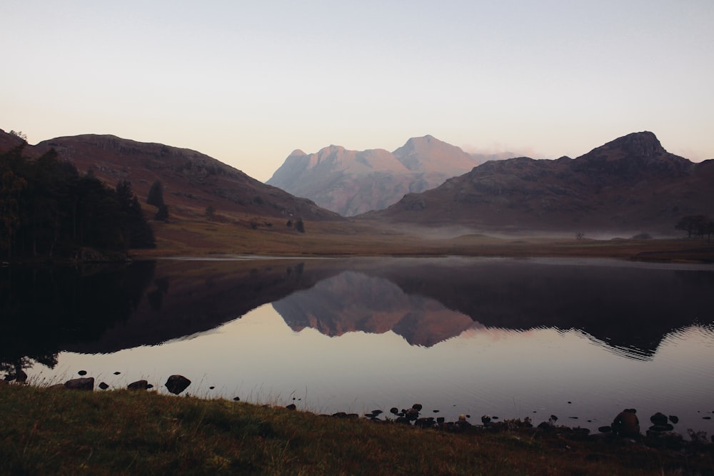 lake in the middle of mountains during daytime