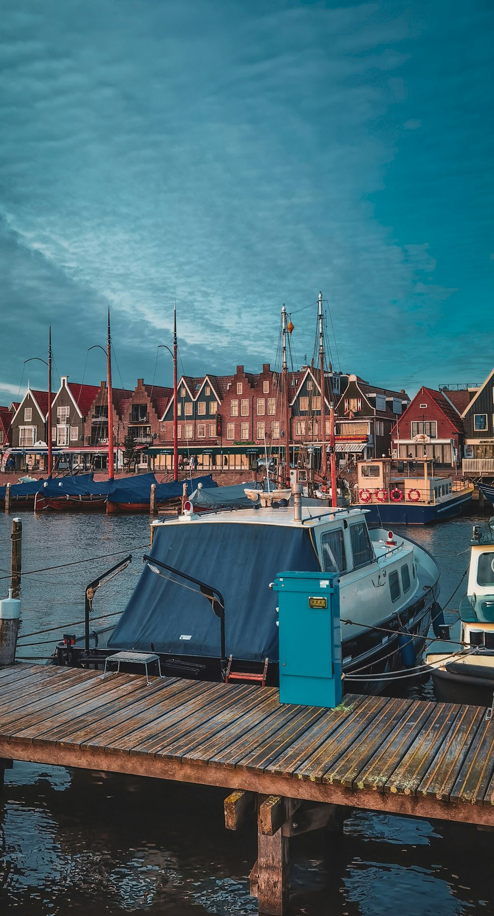 blue and white boat on dock during daytime