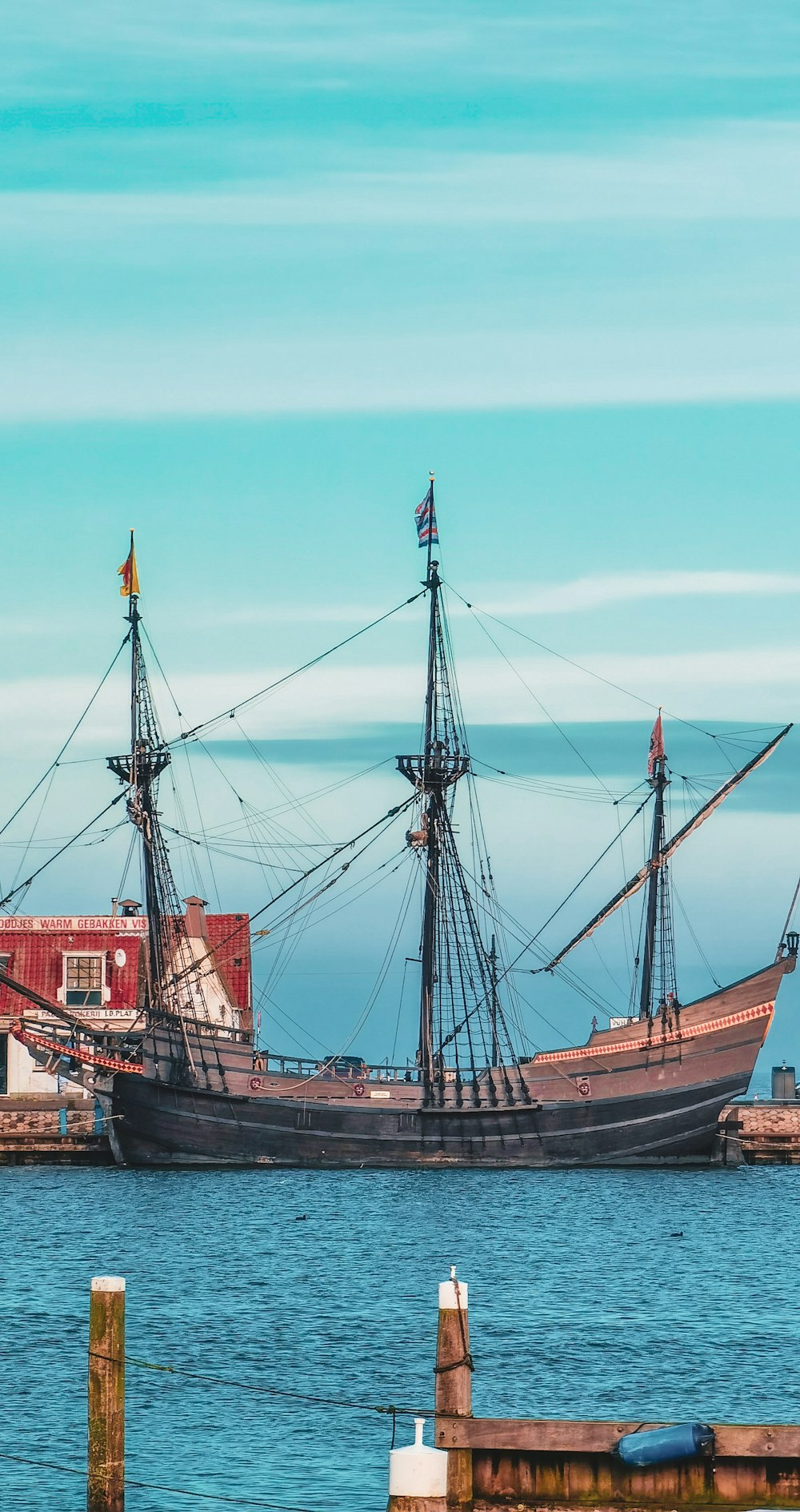 red and black sail boat on sea during daytime