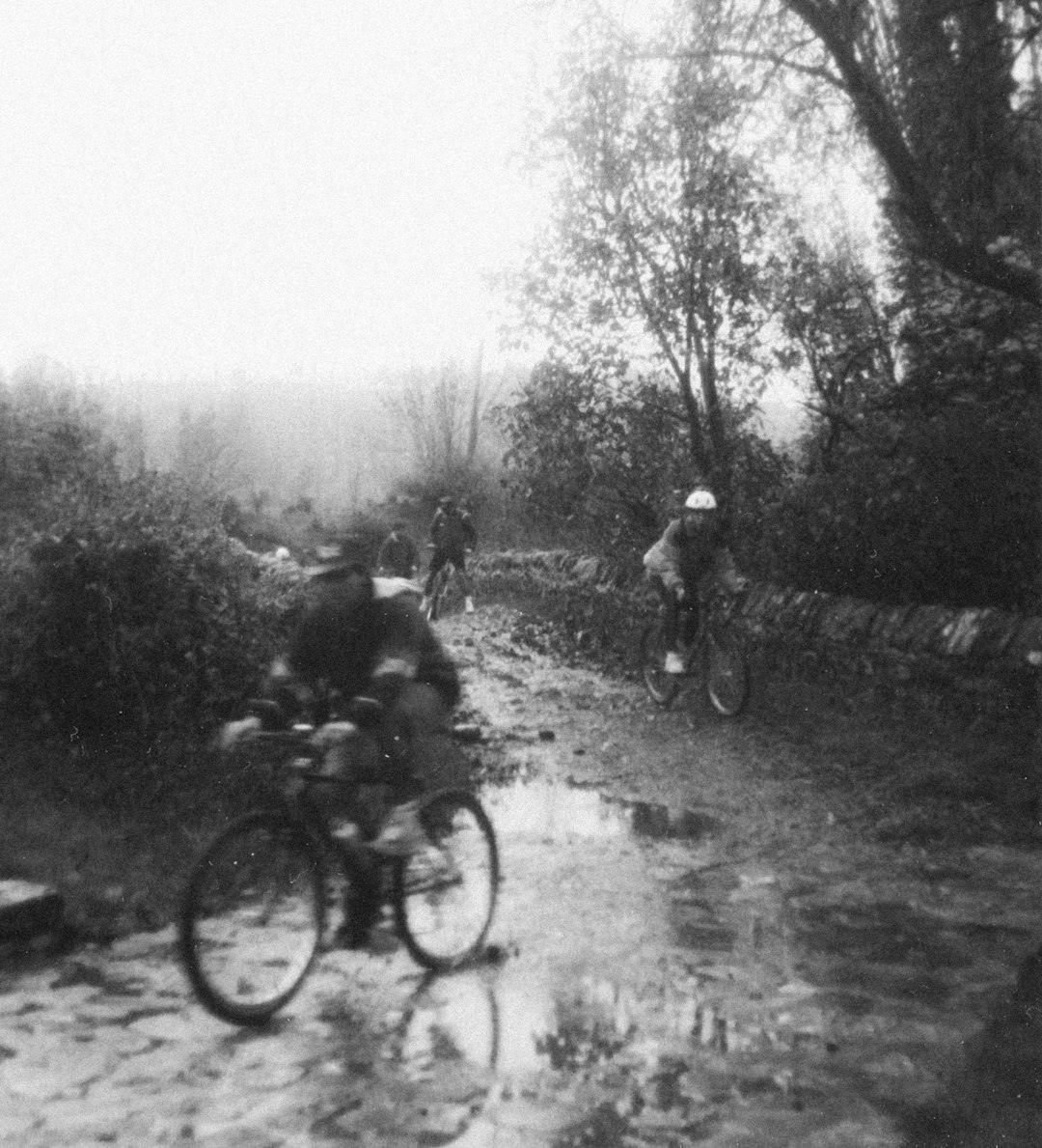 grayscale photo of people riding bicycles