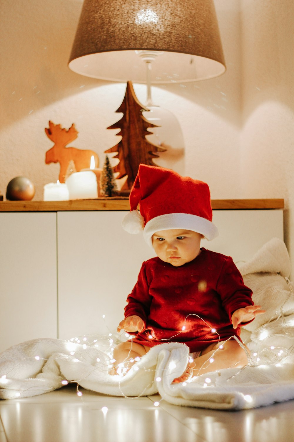 boy in red santa hat sitting on white sofa chair