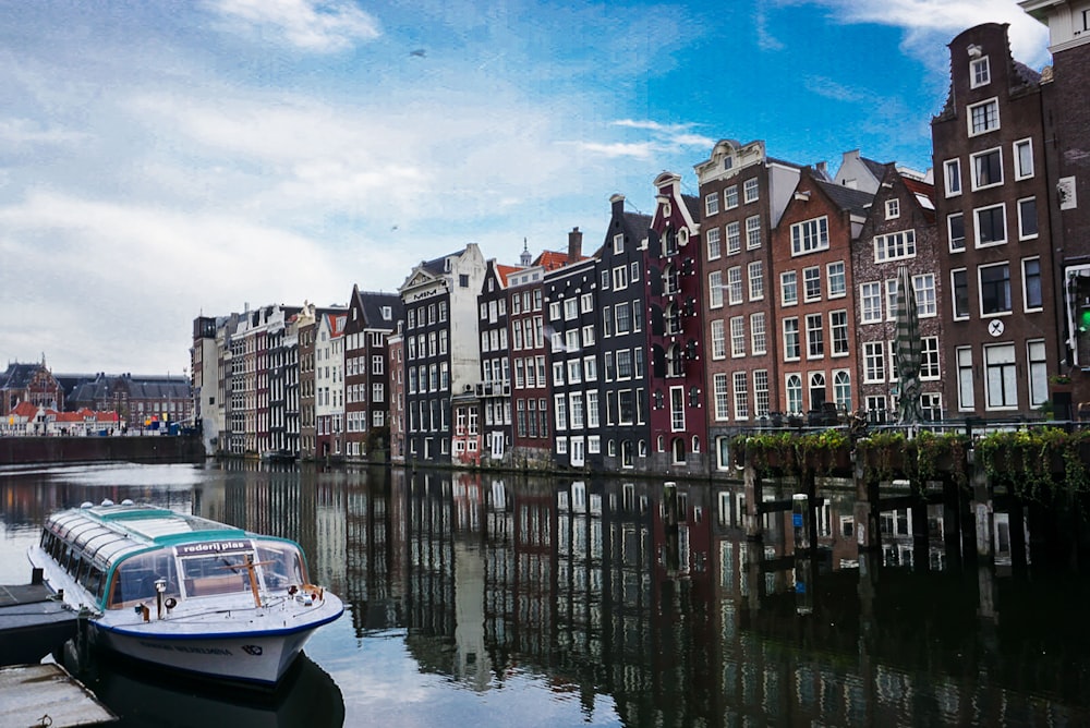 white boat on water near city buildings during daytime