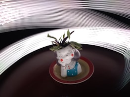 A small ceramic figurine of a girl with a serene expression is placed on a circular red and beige base. The figurine has purple hair, closed eyes, and red cheeks, and is wearing a blue dress with white polka dots. There are green leaves sprouting from the top of the figurine's head. The background features dynamic light trails creating a sense of movement and energy.