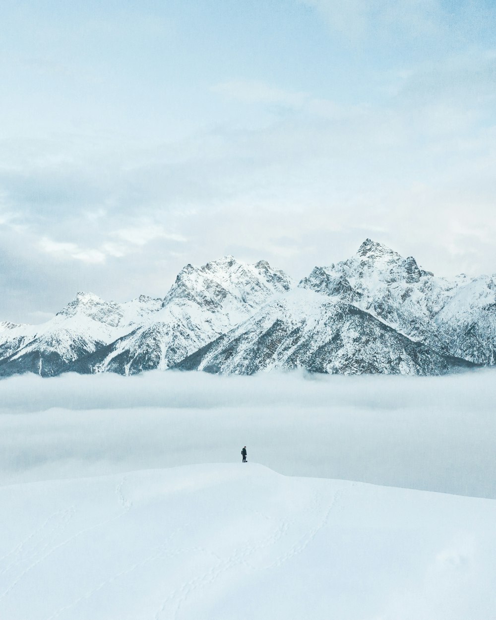 Persona que camina sobre un campo cubierto de nieve durante el día