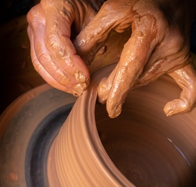 A cheerful pottery wheel spinning with colorful clay shapes forming under gentle hands.