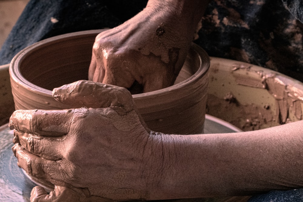 La mano de las personas en el cubo de plástico azul