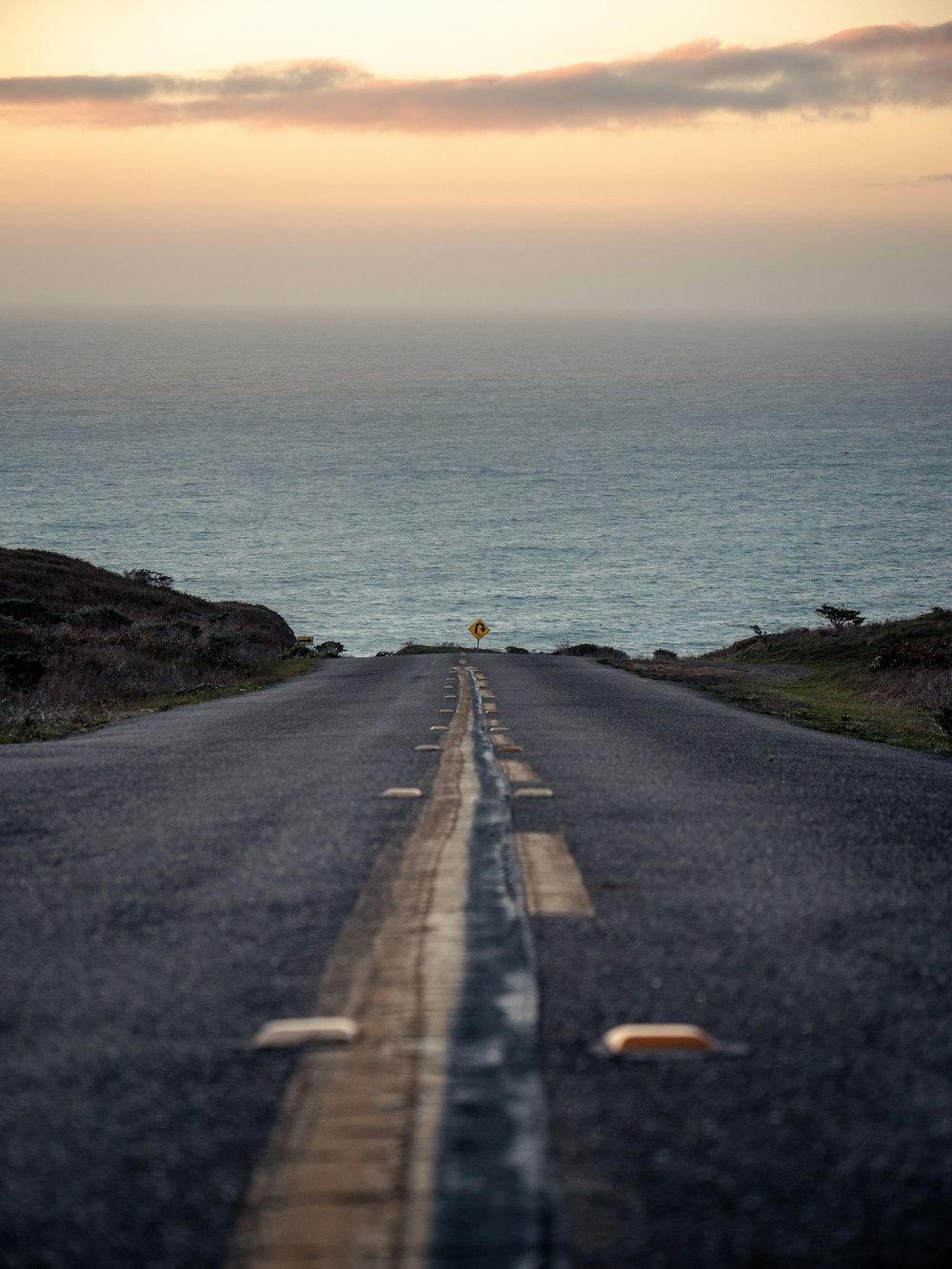 black asphalt road beside body of water during daytime