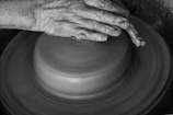 Artisan shaping clay with hands, capturing the craft behind each piece.