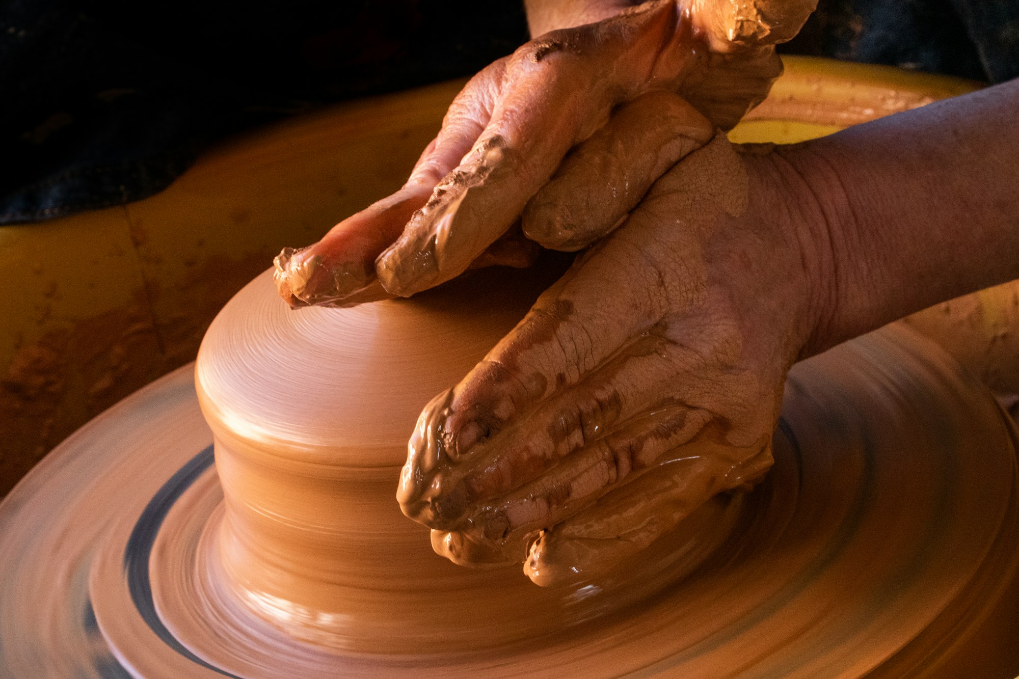 Throwing a clay pot on a potter's wheel.