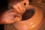 person holding brown clay pot