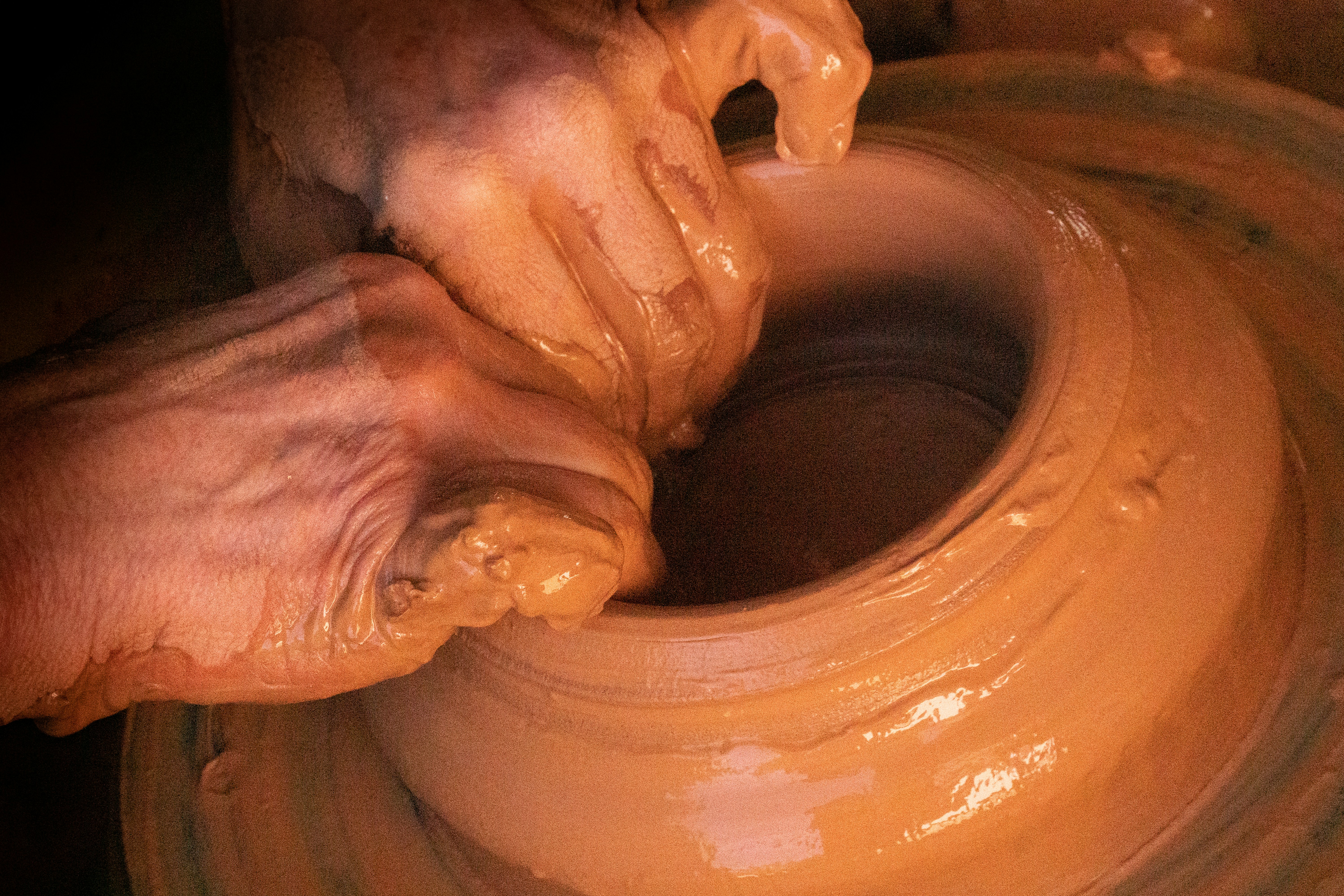 Throwing a clay pot on a potter's wheel.