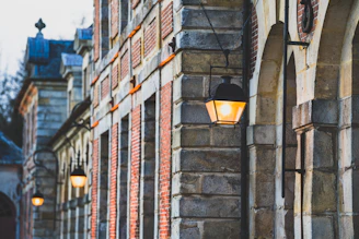 A warm, evening view of the Coin Harvey House glowing softly with antique lantern lights highlighting its Victorian architecture.