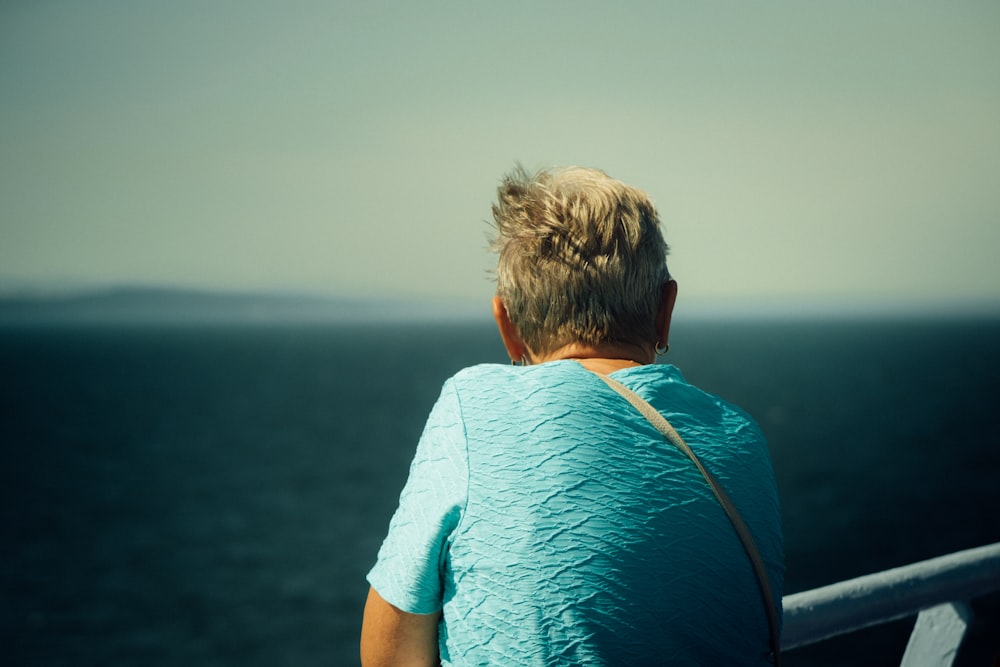 man in blue shirt sitting on boat during daytime