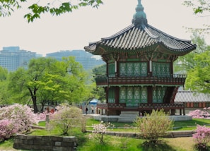 green and brown wooden temple surrounded by green trees during daytime