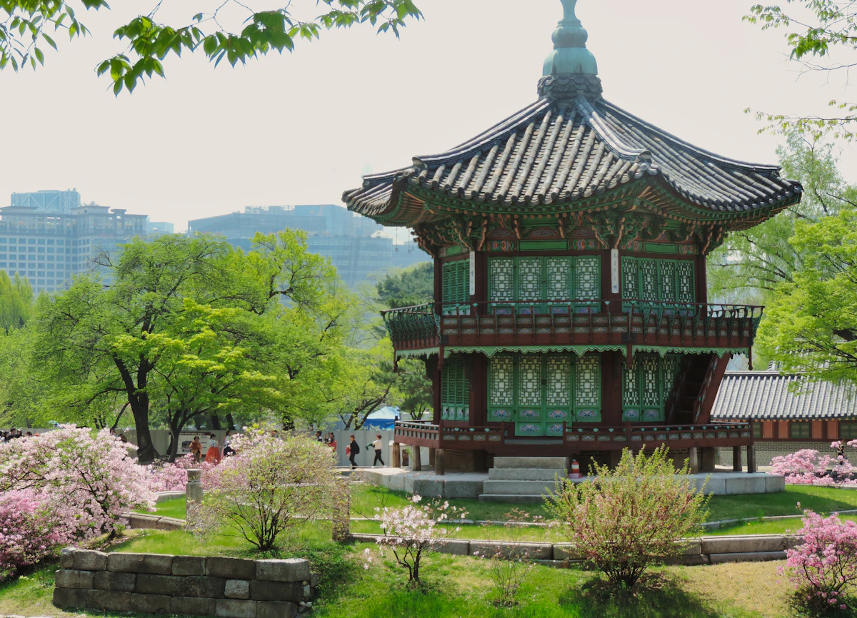 Pavilhão Hyangwonjeong cercado de árvores verdes e flores na primavera