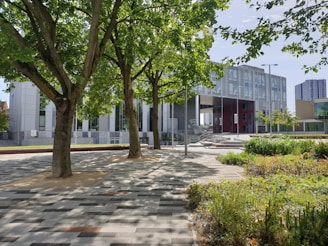 A modern commercial building surrounded by lush greenery.