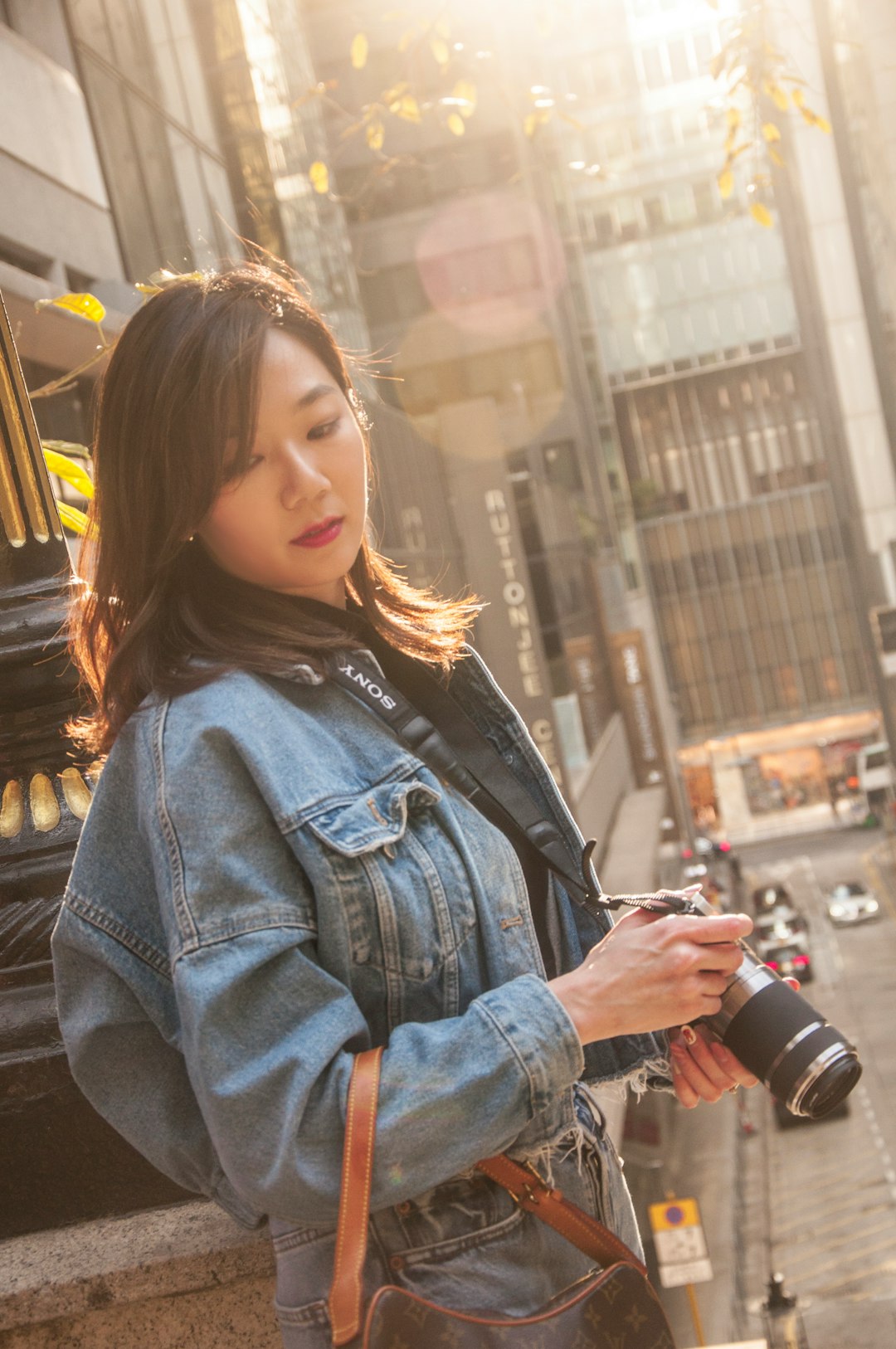 woman in blue denim jacket holding black dslr camera