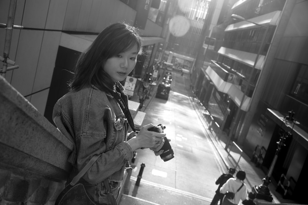 woman in black jacket holding dslr camera