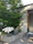 Happy couple admiring their modern concrete patio with decorative accents and lush greenery.