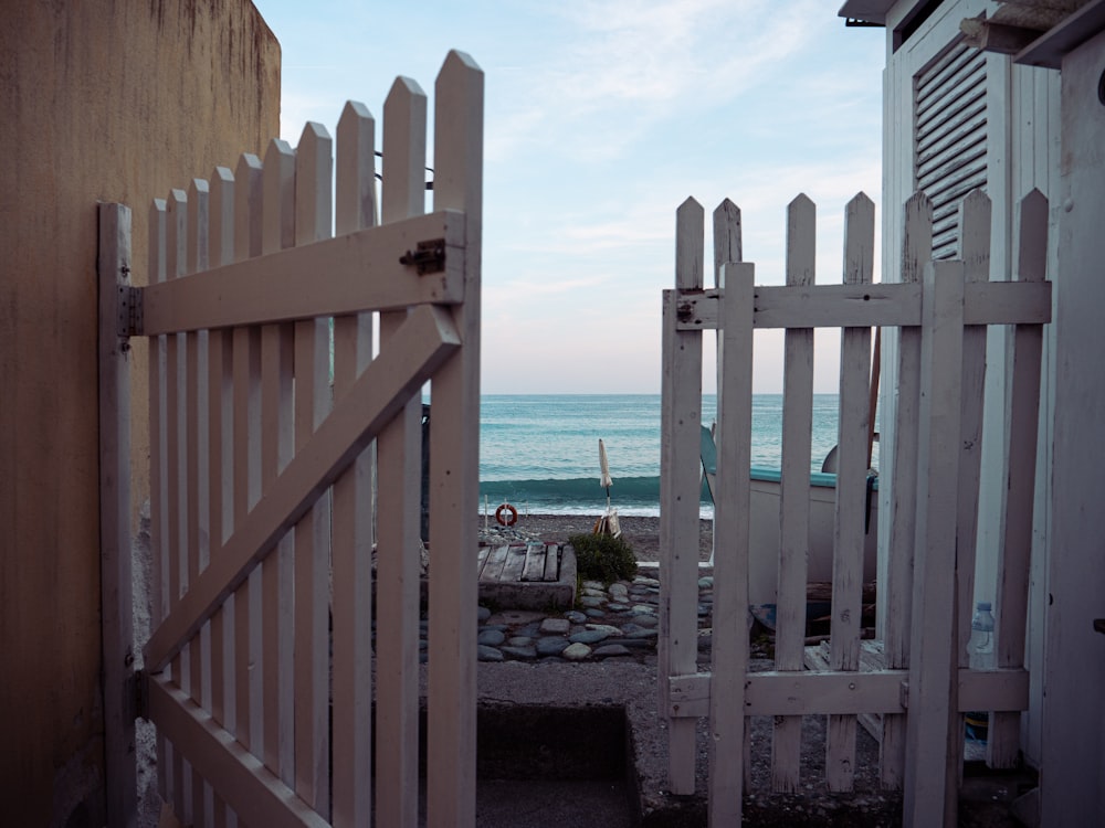 white wooden fence near body of water during daytime