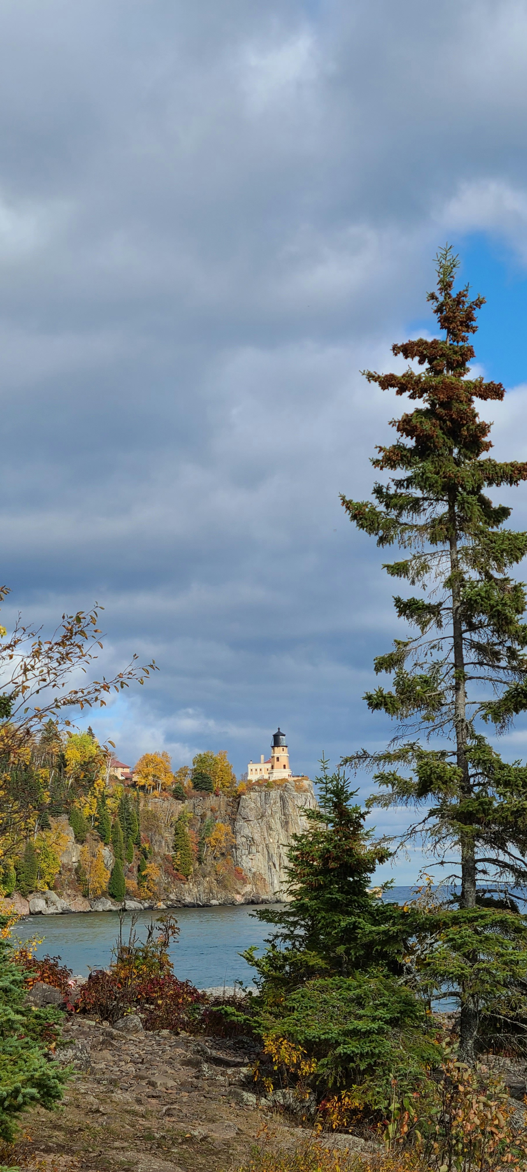 white concrete building near green trees under white clouds during daytime