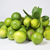 green lemon fruit on white surface