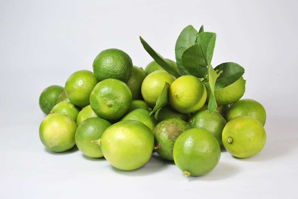 Frutto verde del limone su superficie bianca