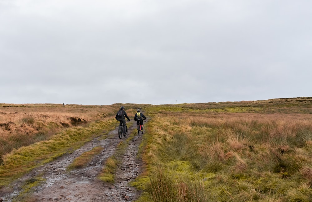 2 person walking on dirt road during daytime