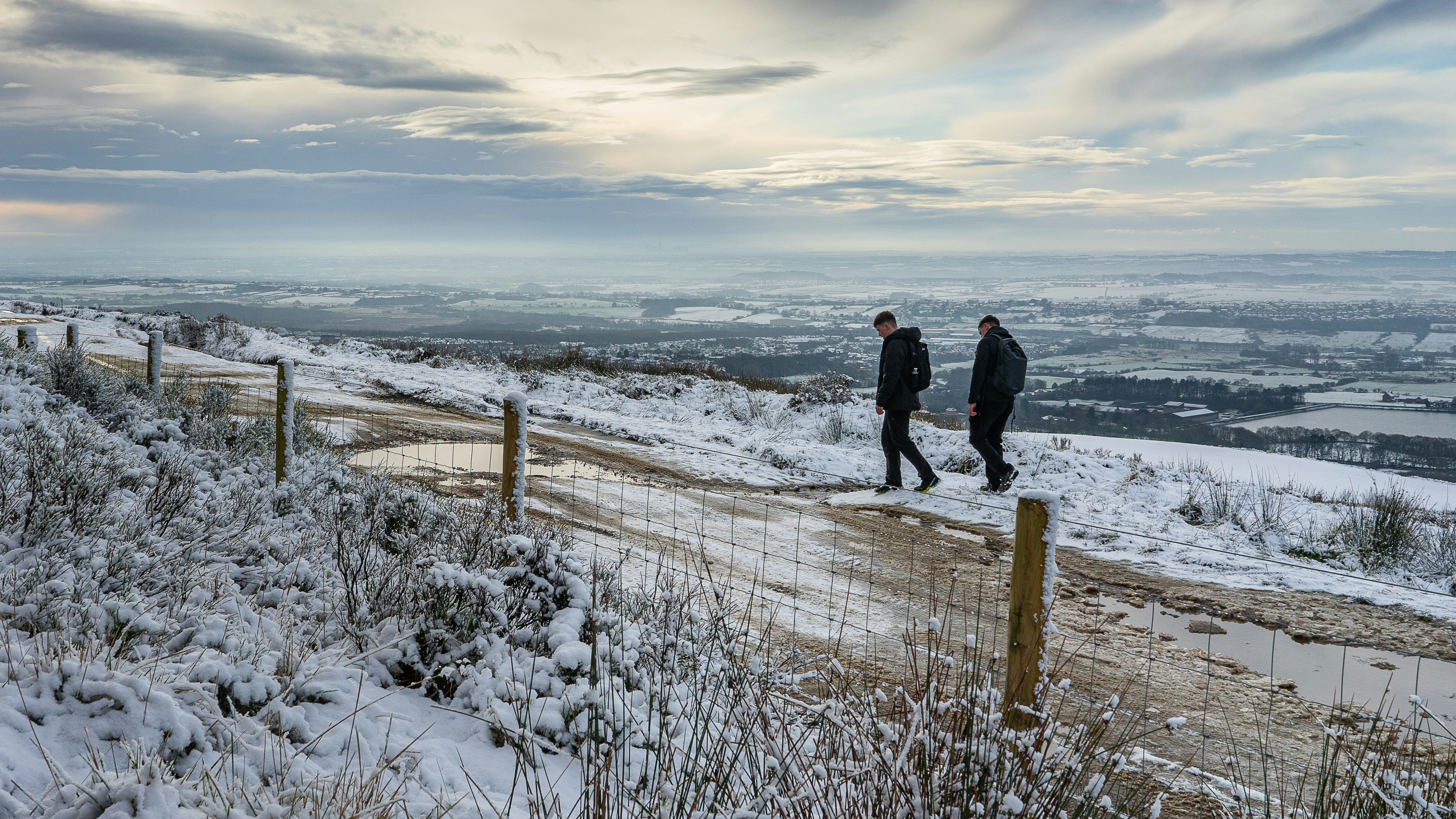 2 person walking on snow covered ground during daytime