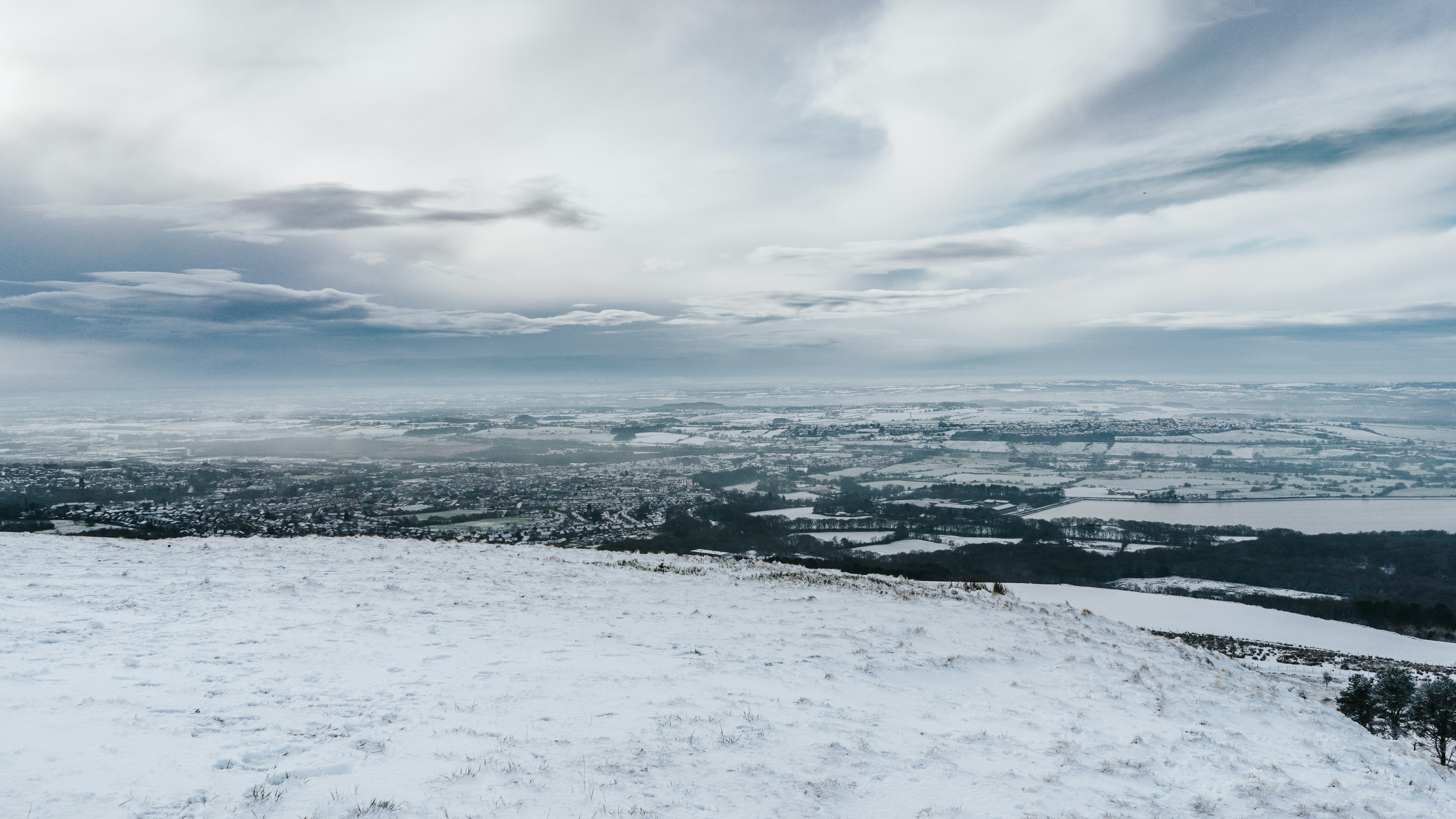 snow covered field under cloudy sky during daytime