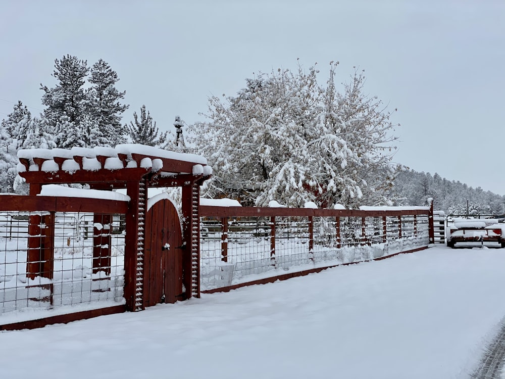 red wooden gate covered with snow