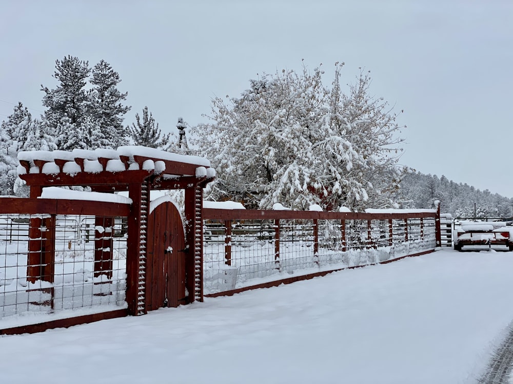rotes Holztor mit Schnee bedeckt