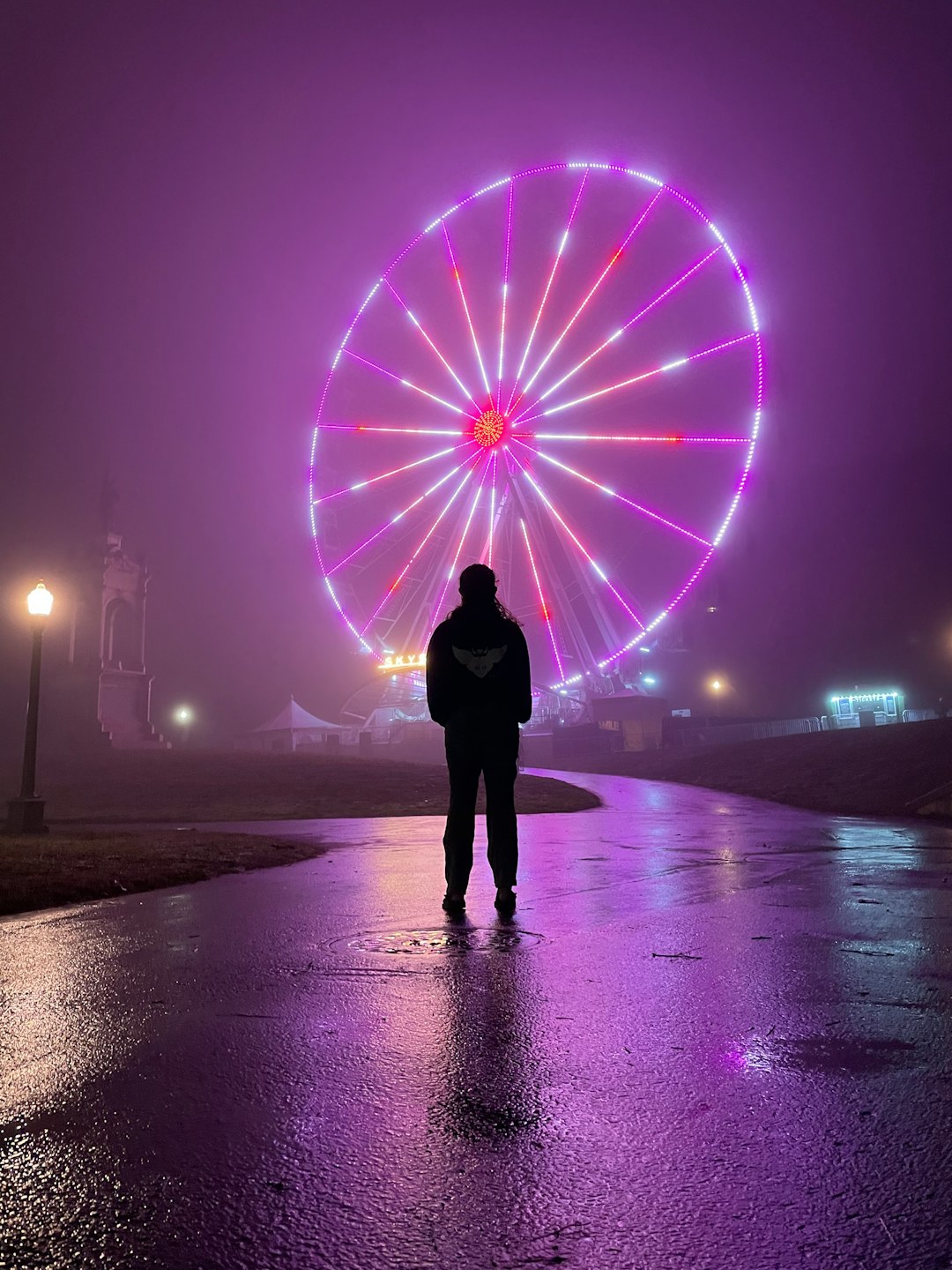person standing on beach with purple lights