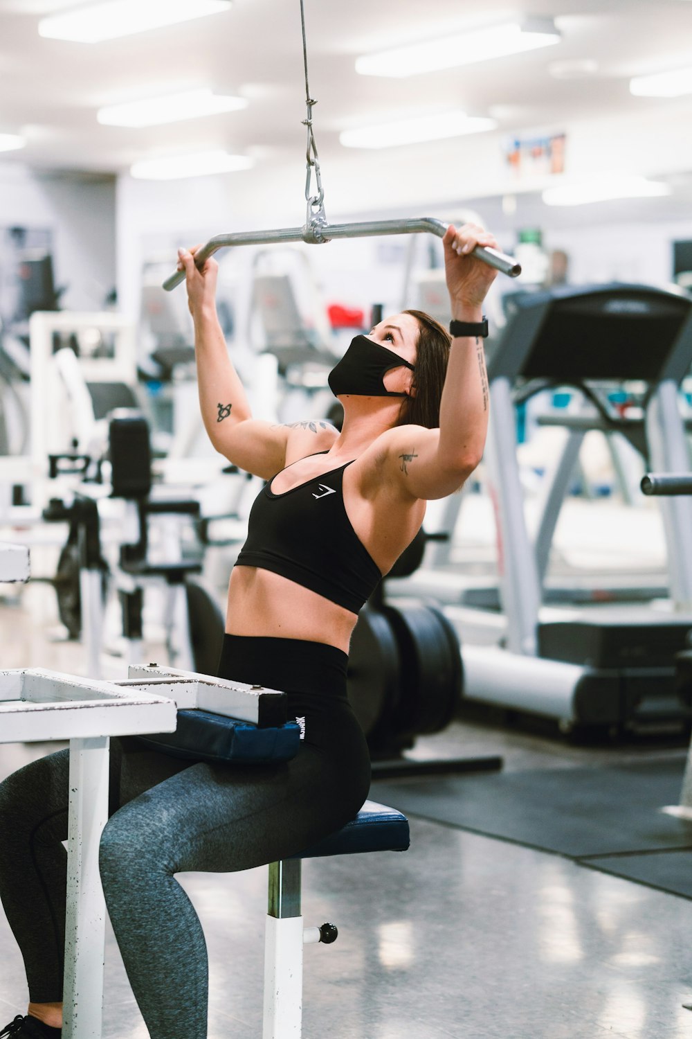 femme en soutien-gorge de sport noir et jean bleu faisant de l’exercice