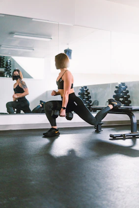 Woman performing a deep squat exercise emphasizing glute muscles in a bright home gym