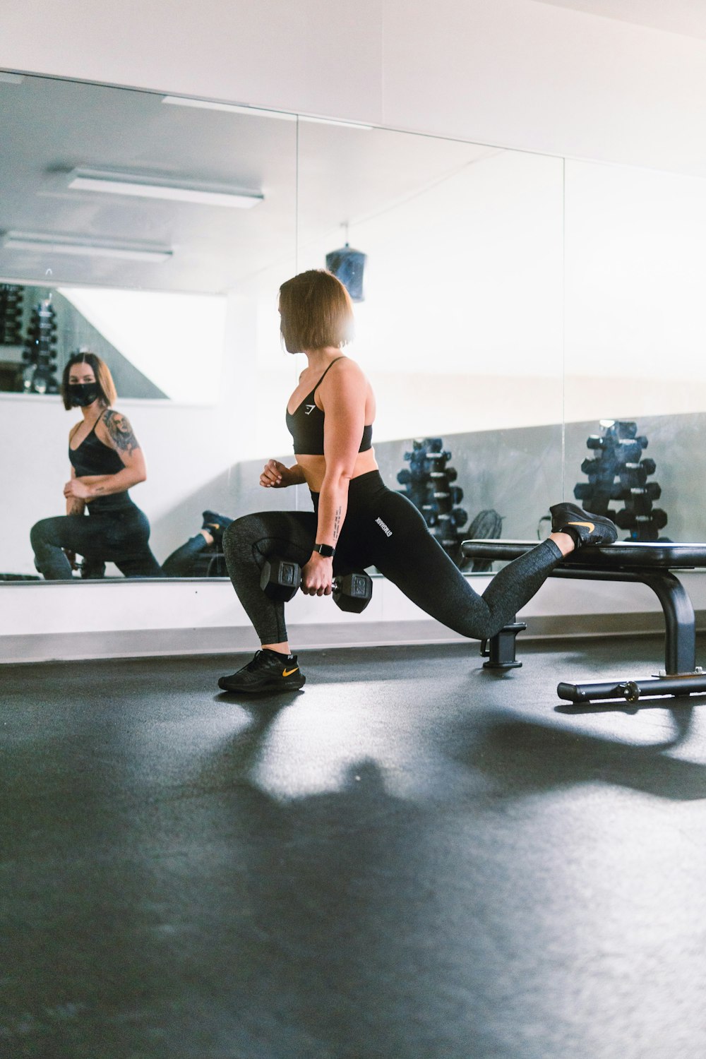 Mujer con sujetador deportivo negro y polainas negras haciendo ejercicio