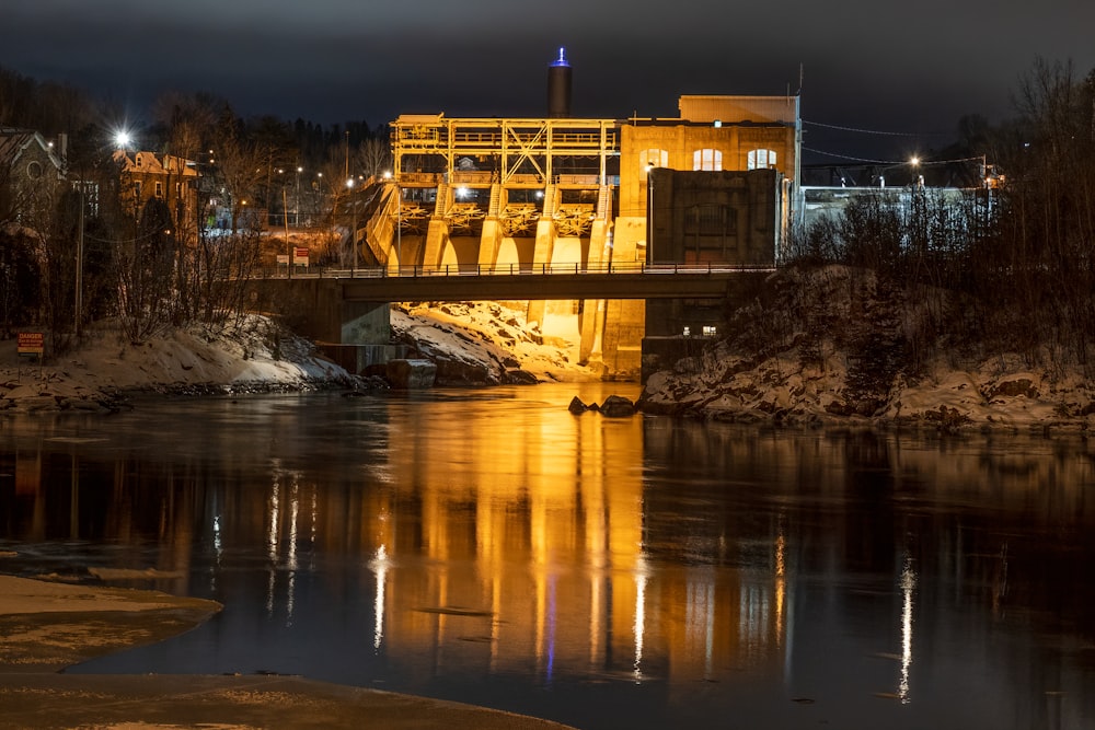 edifício de concreto marrom perto da ponte durante a noite