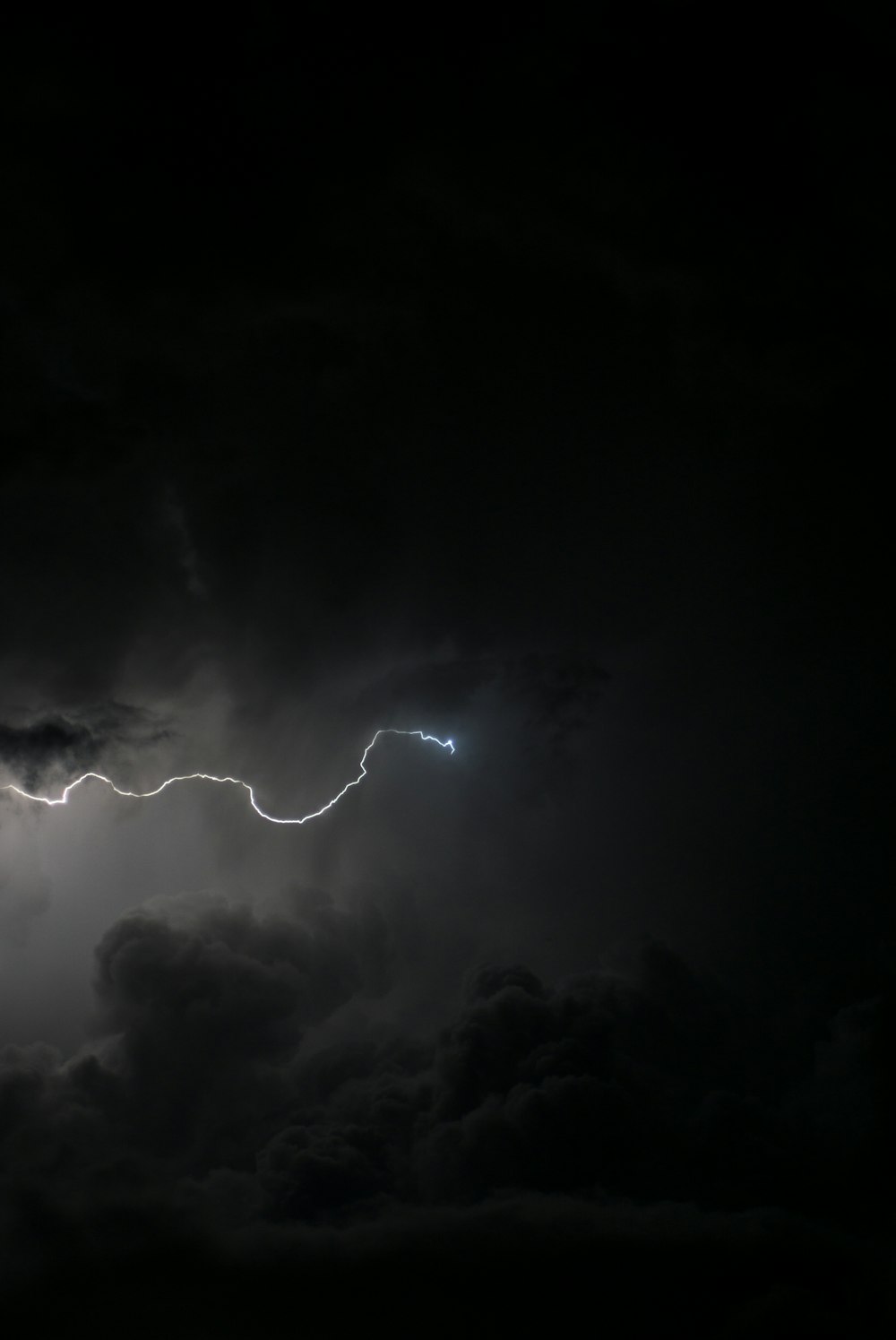 a lightning bolt hitting through a dark cloudy sky