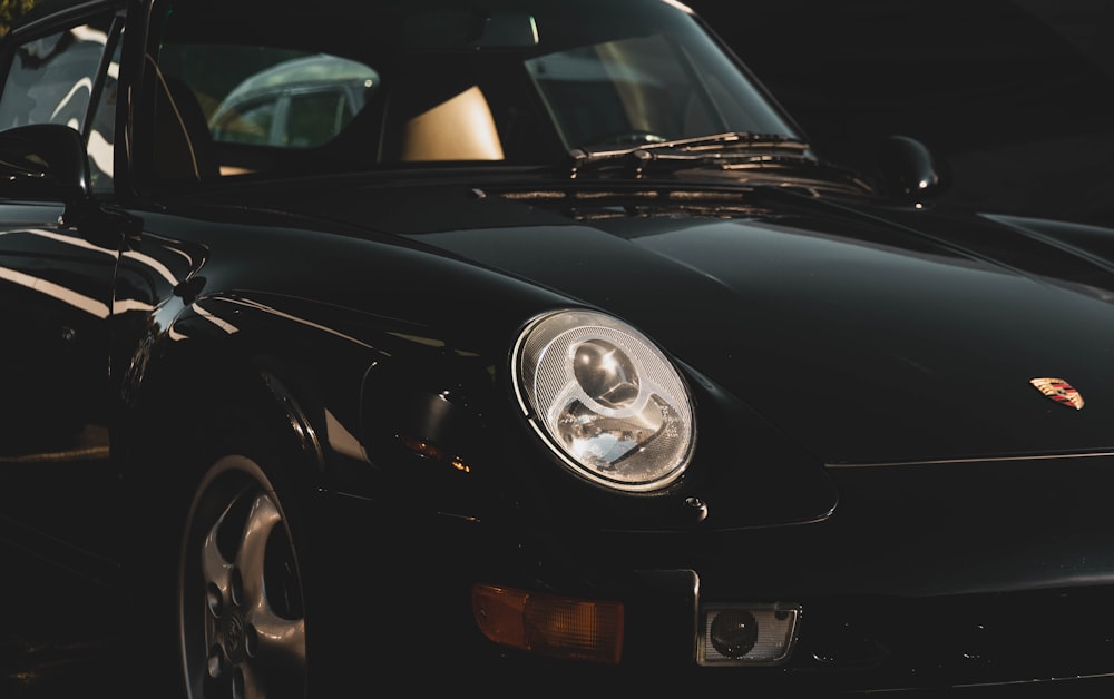 black porsche 911 parked in front of white car