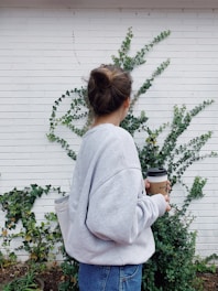 woman in gray sweater holding mug