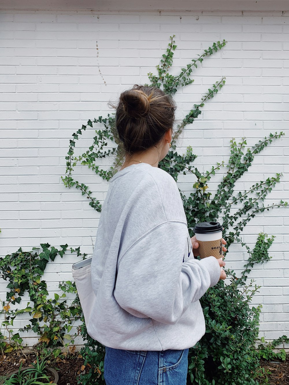 Mujer en suéter gris sosteniendo taza