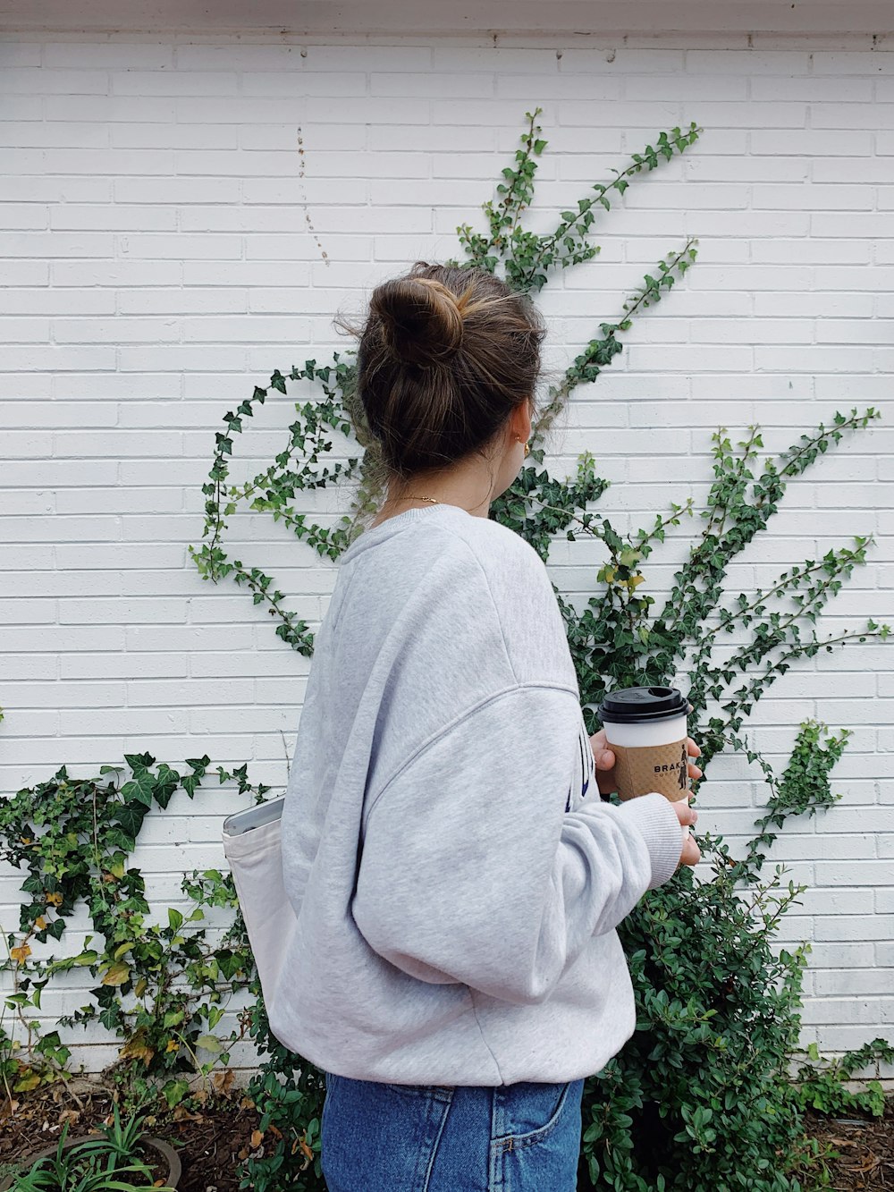 woman in gray sweater holding mug