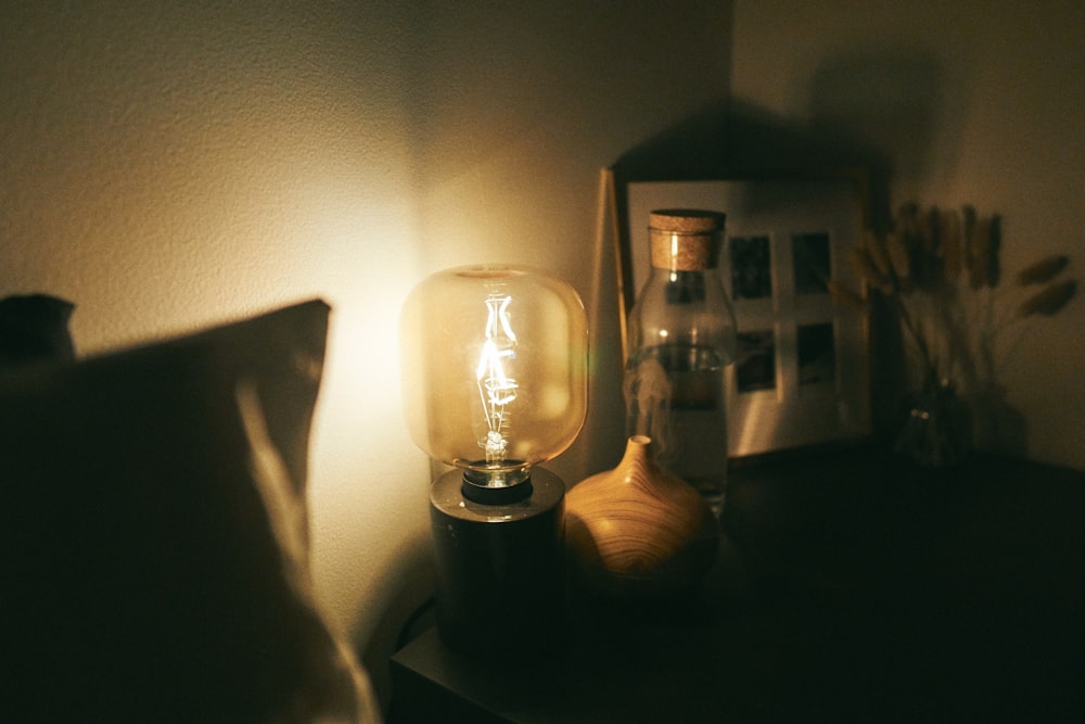 lâmpada de vidro transparente na mesa de madeira preta
