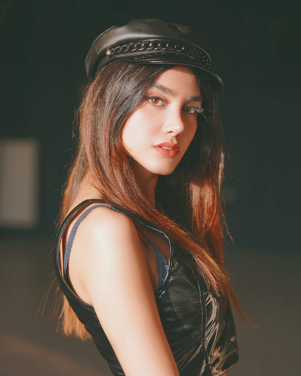 woman in black leather sleeveless top wearing black hat