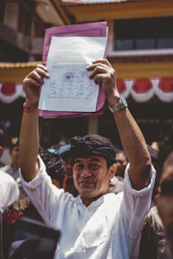 Close-up of hands signing official health permit papers with a stamp nearby.