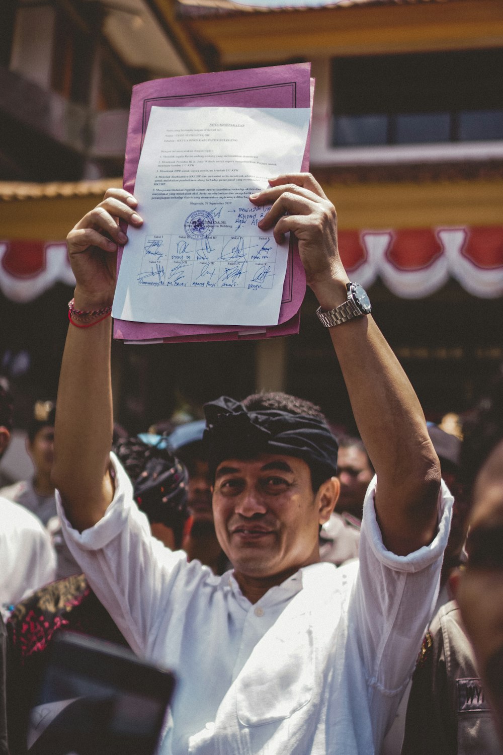 man in white polo shirt holding white printer paper