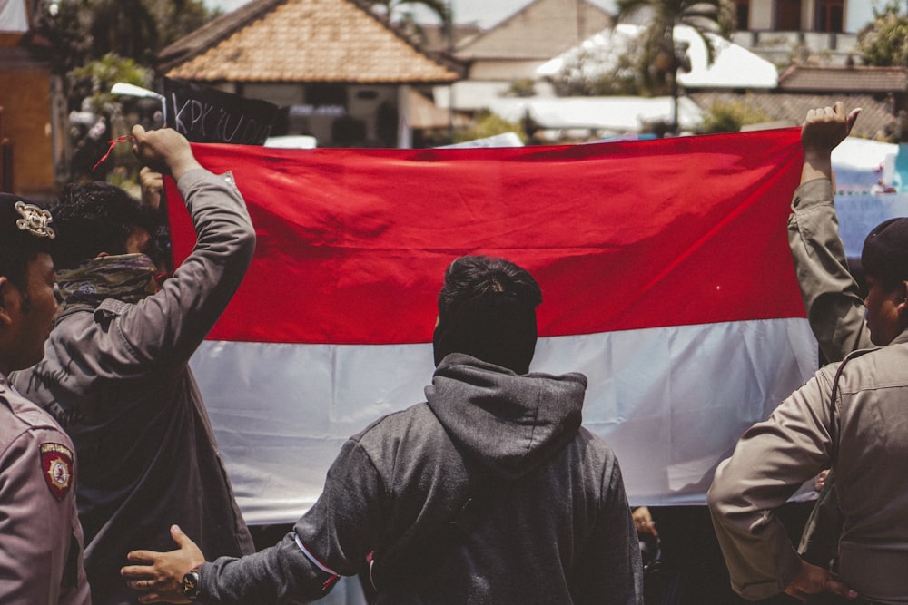 man in black leather jacket holding red flag