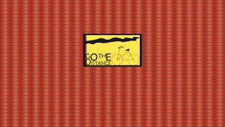 A vividly designed poster features a red bicycle over a bright yellow background with the words 'GO THE DISTANCE' displayed prominently. The backdrop consists of a repetitive red and brown plaid pattern.