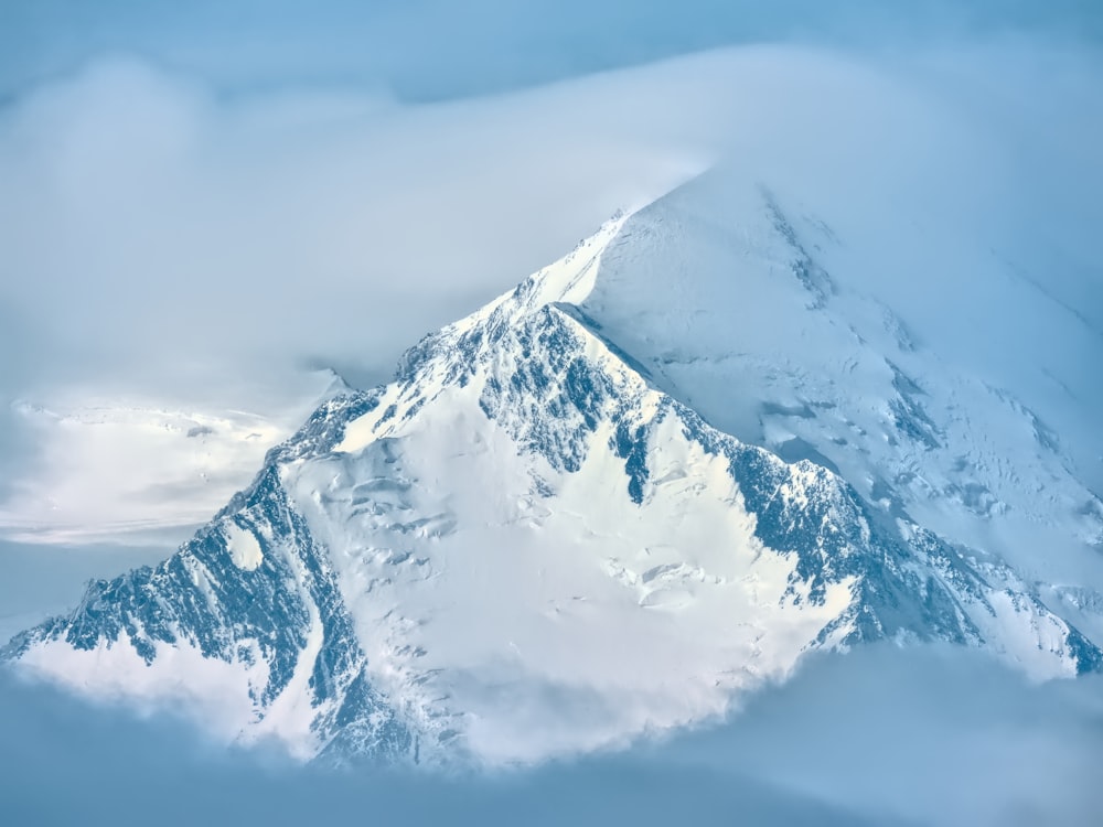 昼間は白い雲の下の雪山