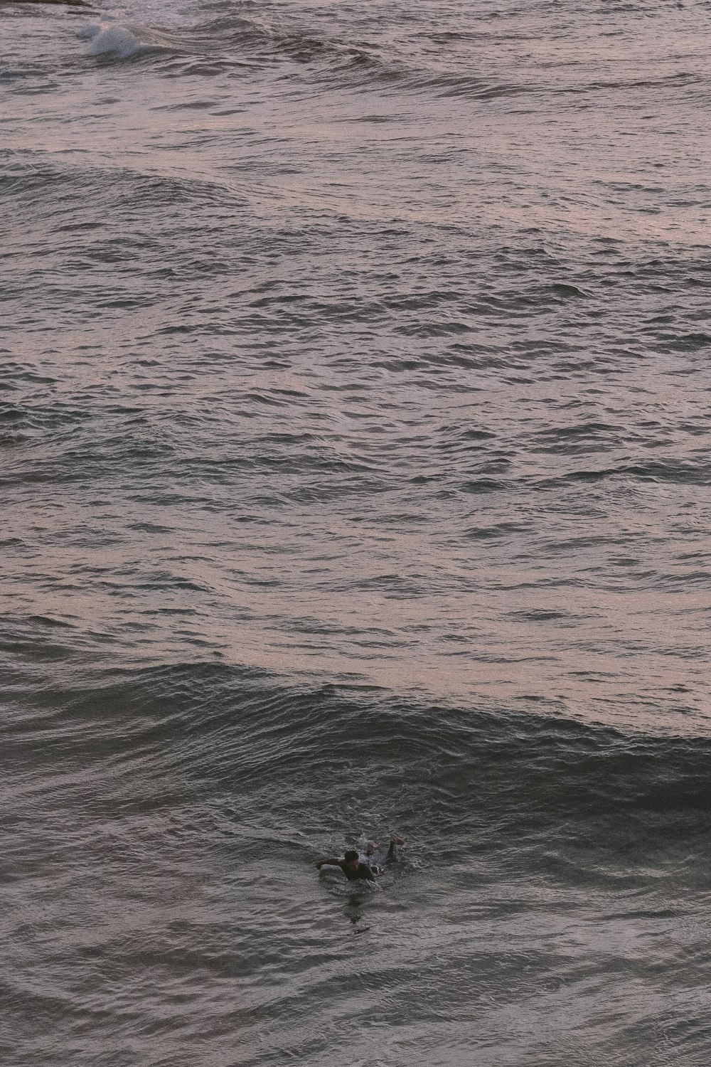 person in black shirt and black shorts standing on body of water during daytime